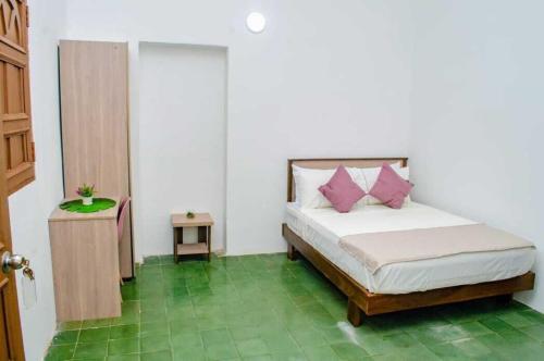 a bedroom with a bed with pink pillows on it at SGH Hotel San Agustin in Santa Marta