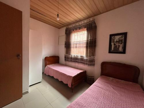 a bedroom with two beds and a window at Casa Gabo in Serra