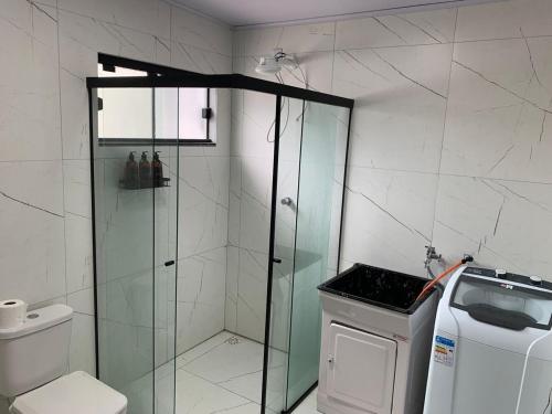 a bathroom with a glass shower and a toilet at Casa com Spa aquecido em Itajuba in Barra Velha