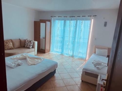 a living room with two beds and a couch at Rozana Rooms in Ulcinj