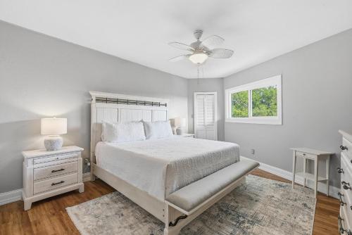 a white bedroom with a bed and a window at Marker 33 #2D3 in New Smyrna Beach