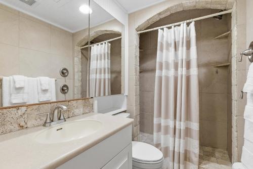 a bathroom with a sink and a toilet and a shower at Marker 33 #2D3 in New Smyrna Beach