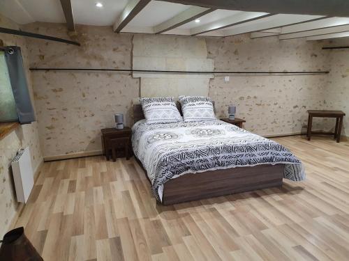 a bedroom with a bed with pillows on it at Gîte de Marcoux, authentic and warme house in Saint-Laon