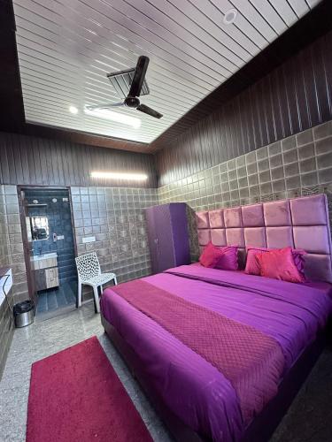 a bedroom with a large purple bed with a pink headboard at Bella Vista Hotel & Home Stay in Mussoorie