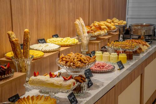 a buffet with many different types of bread and pastries at Hotel Negrini in Balneário Camboriú