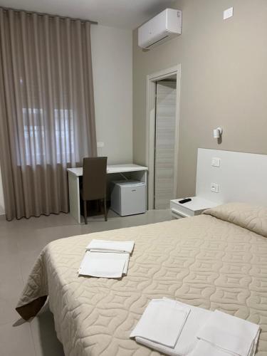 a bedroom with a bed with two towels on it at Afrodite Affittacamere in Metaponto