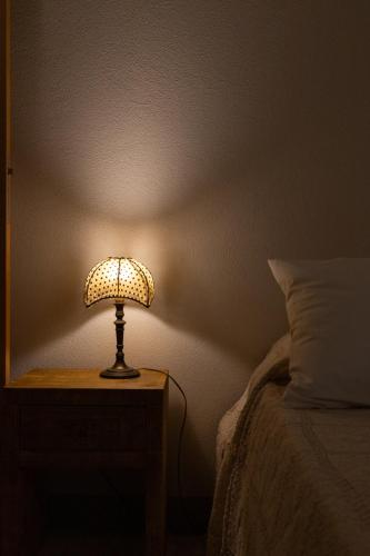 a lamp sitting on a table next to a bed at La Ferrara Agriturismo in Vairano Patenora