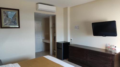 a bedroom with a bed and a tv on the wall at Hotel Del Viajero in Ciudad del Carmen