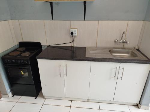 a kitchen with a sink and a stove at Manor Rentals in Potchefstroom