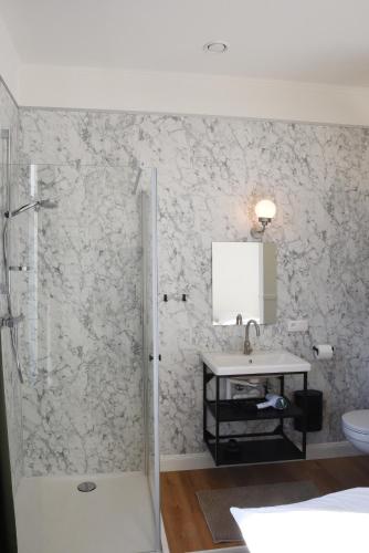 a bathroom with a sink and a shower at Oud Tolkantoor in Alveringem