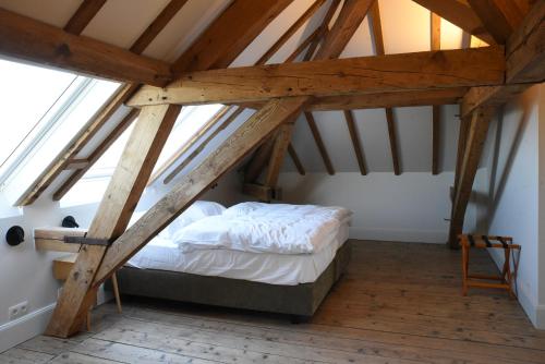 a bedroom with a bed in a attic at Oud Tolkantoor in Alveringem