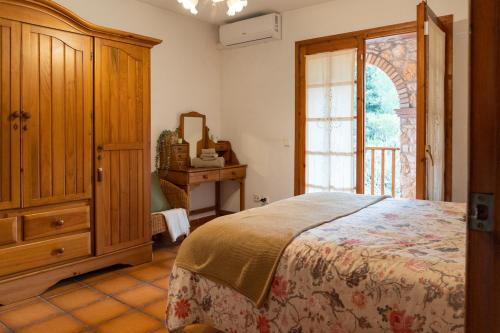 a bedroom with a bed and a dresser and a window at Casa rural La Plana in Alcover
