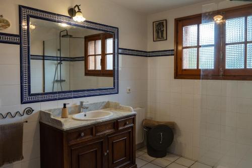 a bathroom with a sink and a mirror and a toilet at Casa rural La Plana in Alcover