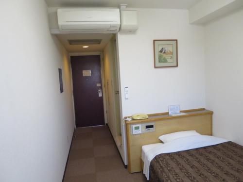 a hotel room with a bed and a hallway at Hotel Heisei in Okazaki