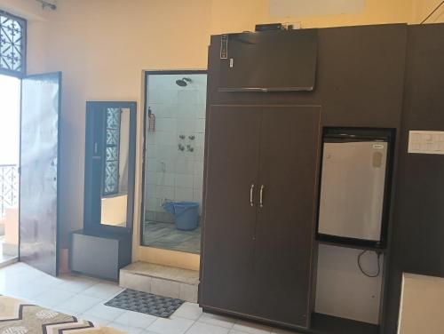 a bathroom with a shower and a sink and a refrigerator at Scindhia Guest House in Varanasi