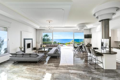 a living room with a couch and chairs and a fireplace at Olymp Luxury Villa А - Beachfront Luxury Living in Kissonerga