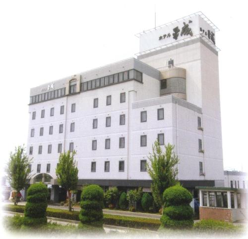 a white building with trees in front of it at Hotel Heisei in Okazaki