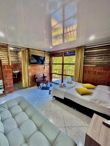 a bedroom with a large bed and a couch at Cabañas San Jose in Doradal