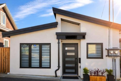 a house with black doors and windows at 2BR Detached Guesthouse - Free Parking -10 mins to YVR & Downtown in Vancouver