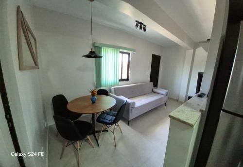 a living room with a table and a couch at Apartamento de curta temporada - ótimo padrão - próximo Lagoa de Iriry in Rio das Ostras