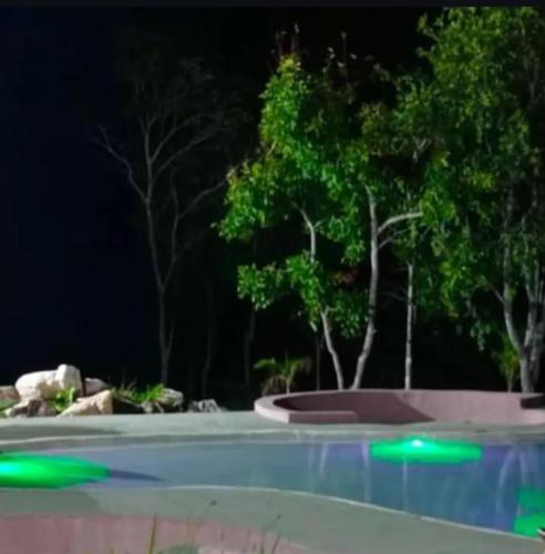 a swimming pool at night with green lights at Pousada Vereda Encantada in São Félix do Tocantins