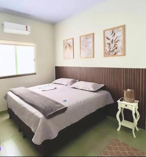 a bedroom with a large bed and a table at Pousada Vereda Encantada in São Félix do Tocantins