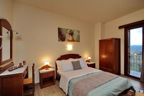 a bedroom with a bed and a window at Valtessiniko Studios in Valtessiniko