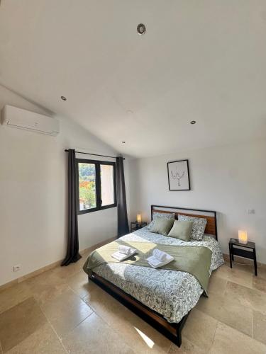 a bedroom with a large bed and a window at Gîte du Colombier in Crestet