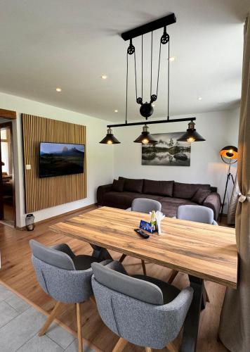 a dining room with a wooden table and chairs at Mountain View Apartment in Kandersteg