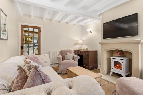 a living room with a fireplace and a tv at WhiskAwayHomes - Hester'sHouse - Luxury Cottage in Broadway