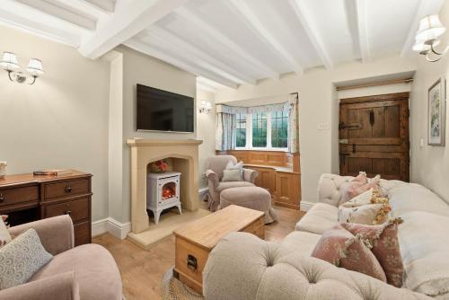 a living room with a couch and a fireplace at WhiskAwayHomes - Hester'sHouse - Luxury Cottage in Broadway