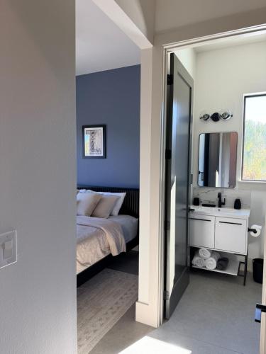 a bedroom with blue walls and a bed and a mirror at New Upscale & Modern Heated Pool Home in Walkable Downtown! in Sarasota