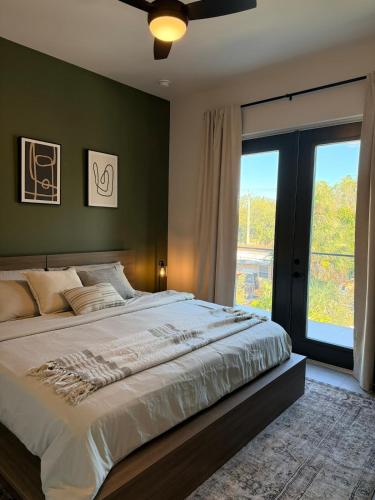 a bedroom with a large bed and a large window at New Upscale & Modern Heated Pool Home in Walkable Downtown! in Sarasota
