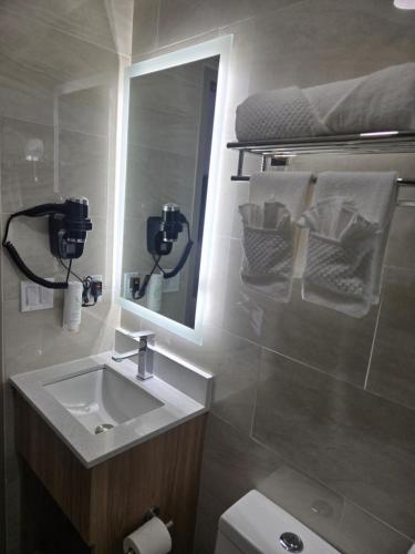 a bathroom with a sink and a mirror and a toilet at Sleep Inn in Brooklyn