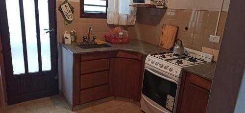 a kitchen with a stove and a sink at Duplex 137 Gesell in Villa Gesell