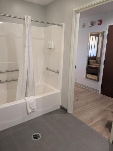 a bathroom with a shower and a bath tub at Microtel Inn & Suites by Wyndham Wheeling at The Highlands in Triadelphia