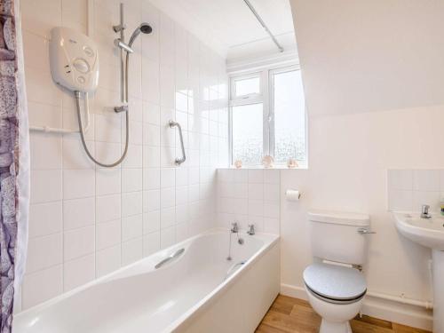 a bathroom with a tub and a toilet and a sink at 2 Bed in Holt oc-73518 in Holt