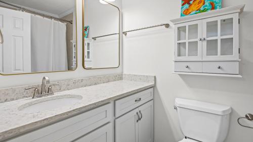 a bathroom with a sink and a toilet and a mirror at Blue Nine 2 in Panama City Beach