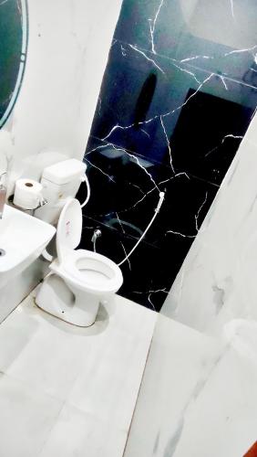 a bathroom with two toilets and a black marble wall at Hotel SK Residency in Varanasi