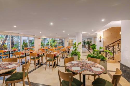 a restaurant with tables and chairs and windows at Pestana Royal All Inclusive Ocean & Spa Resort in Funchal