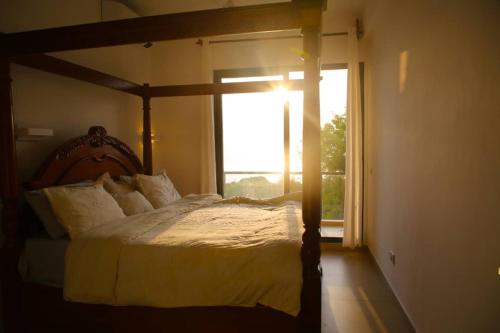 a bedroom with a large bed with a window at Bustani villa in Zanzibar City