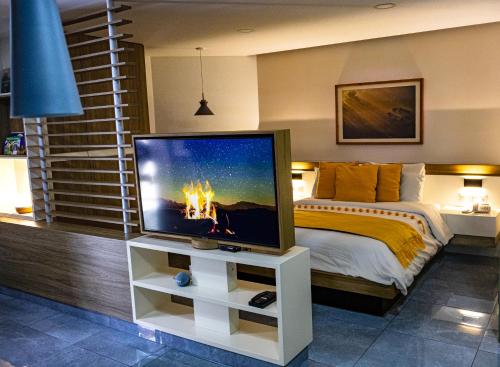 a bedroom with a tv on a stand with a bed at The Lu'um House in Tuxtla Gutiérrez
