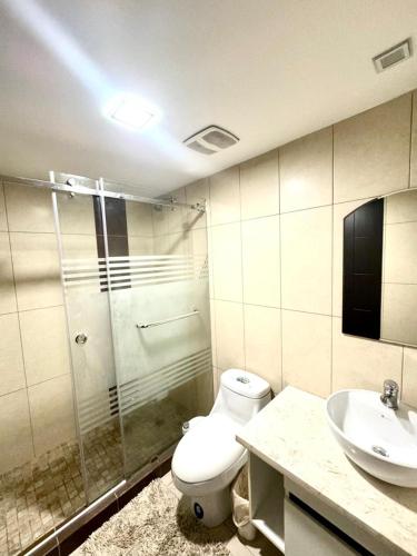 a bathroom with a toilet and a sink at Love Apartment in Guayaquil