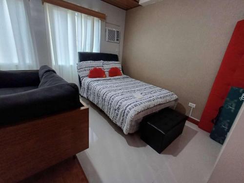 a small bedroom with a bed and a couch at Rye Lees Place in Bacolod