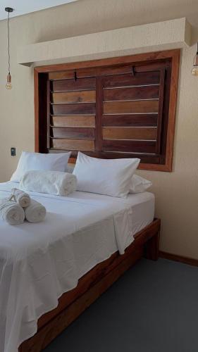 a bed with white sheets and towels on it at Suítes House Refúgio Fortim in Fortim