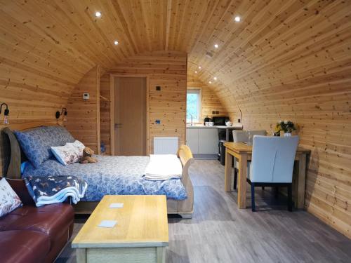 a living room with a bed in a wooden room at Thelmas Lodge in Llanelli