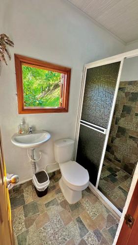a bathroom with a toilet and a sink and a shower at Cabañas San Jose in Doradal