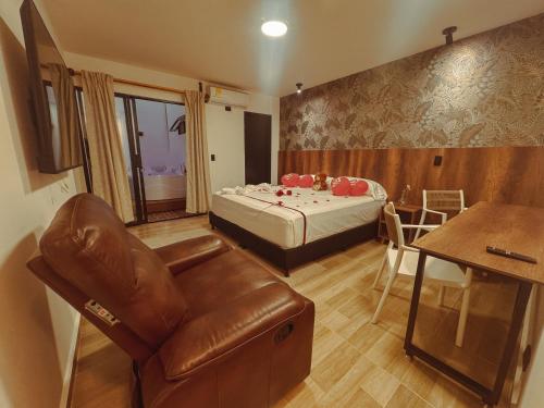 a room with a bed and a couch and a table at Apartaestudios Zeni in Medellín