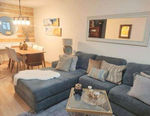 a living room with a blue couch and a table at Apartamento de 3 recámaras en el corazón de puebla in San Baltasar