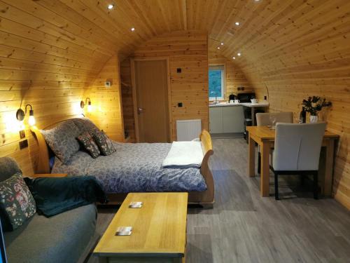 a room with a bed and a table and a kitchen at Lodge 2 in Llanelli